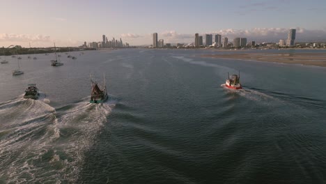 Aerial-view-over-two-trawlers-on-the-Broadwater-on-the-Gold-Coast-moving-towards-Surfers-Paradise,-Queensland,-Australia