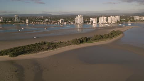 Vista-Aérea-Sobre-La-Isla-Curlew-En-El-Agua-Ancha-En-La-Costa-De-Oro-Moviéndose-Hacia-El-Paraíso-De-Los-Surfistas,-Queensland,-Australia