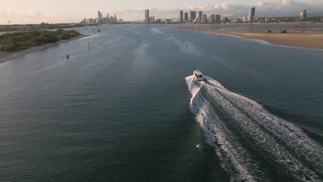 Vista-Aérea-Sobre-Un-Barco-En-El-Agua-Ancha-Moviéndose-Hacia-El-Paraíso-De-Los-Surfistas-En-La-Costa-Dorada-Moviéndose-Hacia-El-Paraíso-De-Los-Surfistas,-Queensland,-Australia