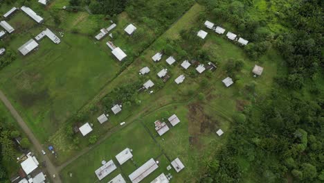 Drone-flying-over-remote-satellite-town-on-a-green-plateau