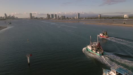 Aerial-view-over-two-trawlers-on-the-Broadwater-on-the-Gold-Coast-moving-towards-Surfers-Paradise,-Queensland,-Australia