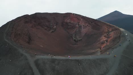 Los-Turistas-Caminan-En-El-Cráter-Del-Volcán-Monte-Etna-En-Sicilia,-Italia---Círculos-Aéreos-4k