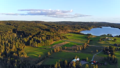 Drone-footage-over-farmers-village,-fields-and-lakes-in-Sweden