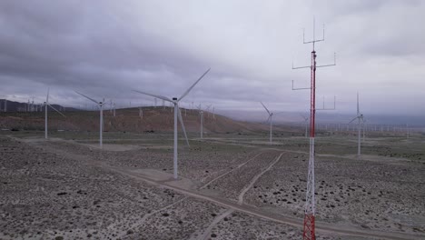 Aerial-footage-of-a-wind-farm-in-the-Palm-Springs-desert-on-a-cloudy-day,-slow-vertical-dolly-shot
