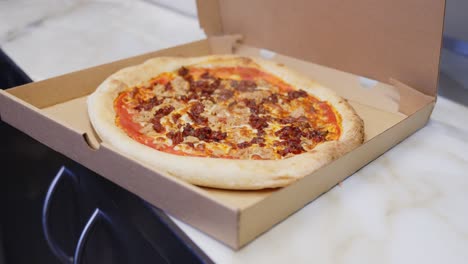 Freshly-cooked-pizza-steaming-inside-cardboard-box,-ready-for-takeaway