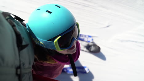 Happy-little-girl-looking-up-at-father-riding-snowy-resort-ski-lift-together