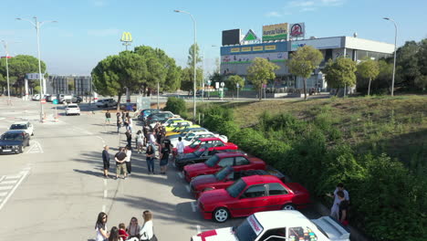 Vista-Aérea-Sobre-La-Fila-De-Autos-Clásicos-Bmw-Serie-E30-Estacionados-En-Una-Reunión-De-Fans-Bajo-La-Señalización-De-Mcdonalds