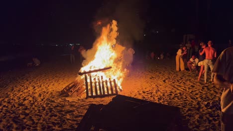 Festival-Tradicional-De-Hogueras-En-La-Playa-En-La-Celebración-De-San-Juan-En-Marbella-España,-Gente,-Amigos-Y-Familiares-Disfrutando-De-Una-Fiesta-Divertida-Durante-El-Verano,-Gran-Fuego-Ardiente-Y-Llamas-Calientes,-Tiro-De-4k