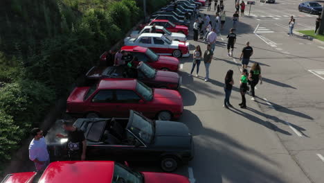 Vista-Aérea-Sobre-La-Fila-De-Autos-Clásicos-Bmw-Serie-E30-Estacionados-En-La-Reunión-De-Fans-De-Manresa