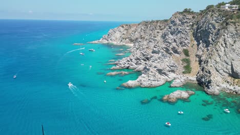 Capo-Vaticano,-Boats-sailing-around-Coast-and-Beaches-in-Calabria,-South-Italy---Aerial-4k