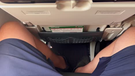 Viajando-En-Un-Asiento-De-Avión-Apretado-Con-Muy-Poco-Espacio-Para-Las-Piernas,-Piernas-Y-Rodillas-Masculinas-Apretadas-En-Un-Avión-De-Las-Aerolíneas-Turcas,-Asiento-Incómodo-De-La-Aerolínea,-Toma-De-4k