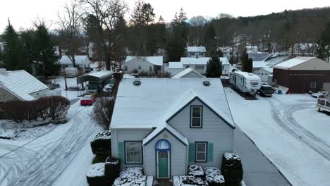 Aerial-rising-shot-of-small,-quaint-house-covered-in-snow
