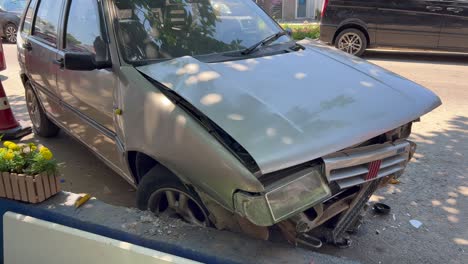 Old-car-crashed-near-sidewalk,-big-dangerous-accident,-broken-car-on-the-road,-car-insurance-damage,-4K-shot