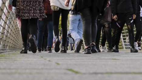 Close-up-of-pedestrians-feet-crossing-the-Millennium-Bridge-over-the-Thames