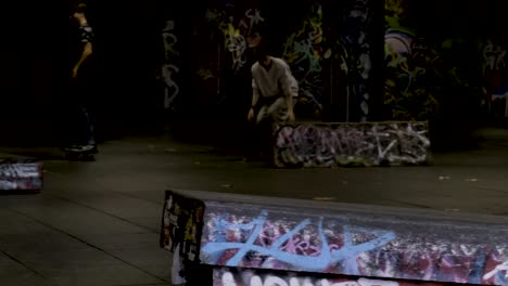 Ein-Skateboarder-Macht-Einen-Sprung-Als-Leute,-Die-Im-Skatepark-Southbank-Centre,-London,-Großbritannien,-Skateboard-Fahren