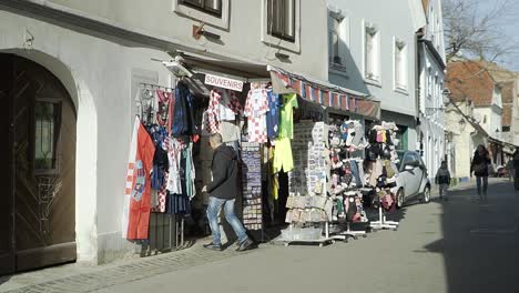 Male-hispanic-tourist-entering-a-small-tourist-boutique-in-Zagreb,-Croatia