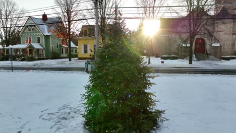 Langsame-Luftumkreisung-Um-Den-Geschmückten-Weihnachtsbaum,-Umgeben-Von-Weißem-Schnee-Und-Hellem,-Intensivem-Sternensonnenschein-An-Kalten-Wintertagen