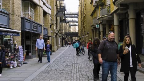 Londres-Shad-Thames-Calle-Adoquinada-Con-Gente-Y-Bicicletas-En-Cámara-Lenta