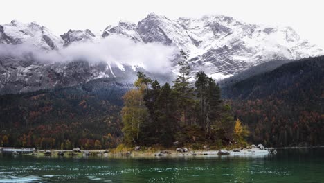 View-of-beautiful-island-on-lake-Eibsee-in-Bavaria,-Germany,-mountain-zugspitze-in-background