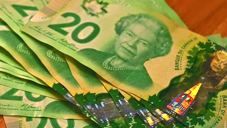 Pila-De-Billetes-Canadienses-De-20-Dólares-Arrojados-Sobre-La-Mesa-Mientras-Gira,-Primer-Plano