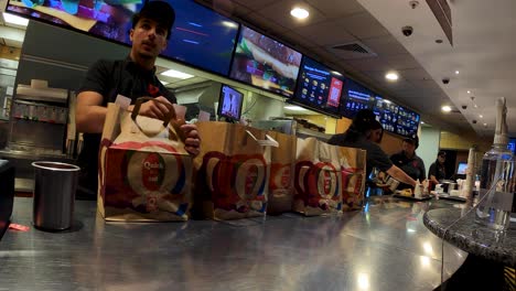 POV-delivery-food-courier-picking-up-paper-bag-in-Quick-Hamburger-restaurant-service-area---Brussels,-Belgium