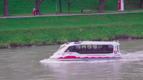 A-small-sightseeing-boat-on-Salzach-river-in-Salzburg,-Austria