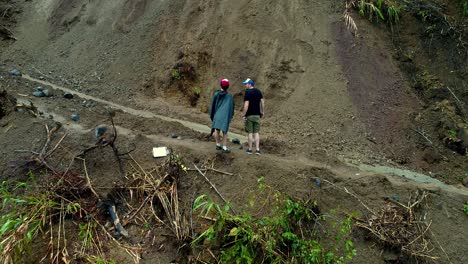 Dos-Hombres-Señalando-Y-Gesticulando-Ante-Un-Derrumbe-En-Las-Montañas-Filipinas