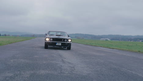 Ford-Mustang-Mach-1,-Conduciendo-Un-Coche-Deportivo-Clásico-De-La-Década-De-1960-En-Carretera,-Cámara-Lenta