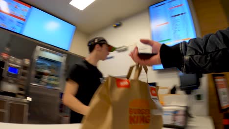 Mensajero-De-Comida-De-Entrega-De-Pov-Recogiendo-Una-Bolsa-De-Comida-De-Papel-En-El-área-De-Servicio-Del-Restaurante-Burger-King---Bruselas,-Bélgica