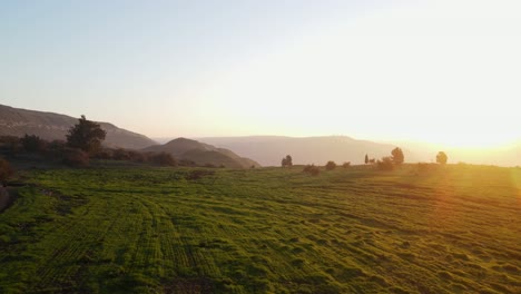 Drone-flyover-of-Israel-landscape,-south-of-Golan,-at-dawn-with-sun-flares