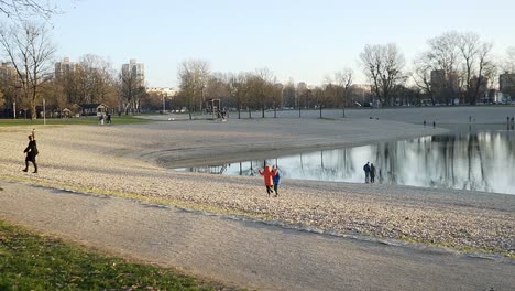 People-walking-on-the-small-beach-lake-in-the-suburbs-of-Zagreb,-Croatia