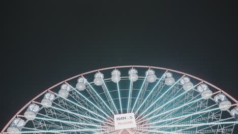 Schwenken-Sie-Nachts-Auf-Dem-Weihnachtsmarkt-über-Ein-Riesiges-Beleuchtetes-Leuchtendes-Riesenrad