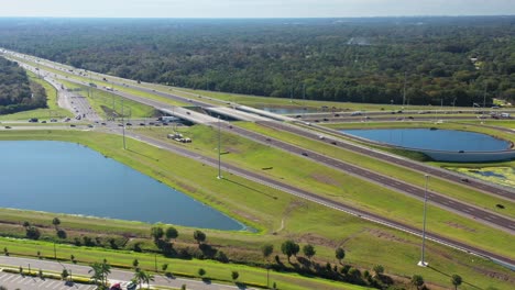 Aerial-landscape-of-highway-junction-road-with-two-roadside-ponds,-low-traffic-intensity-during-sunny-day-near-Sarasota,-Florida