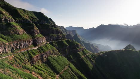 Aerial-reveal-of-rocky-mountain-pass-valley-in-a-green-environment,-Madeira