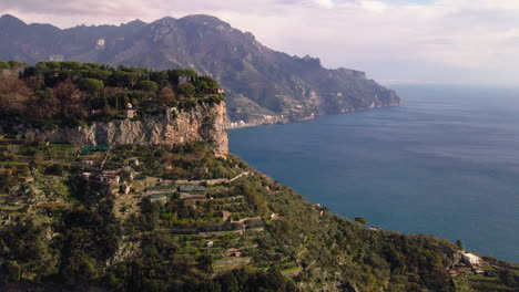 Lush-Mediterranean-mountain-aerial-view-to-reveal-Amalfi-town-Italian-coastline