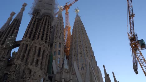 Sagrada-Familia-Neben-Hoch-Aufragenden-Kränen-An-Einem-Sonnigen-Tag-In-Barcelona