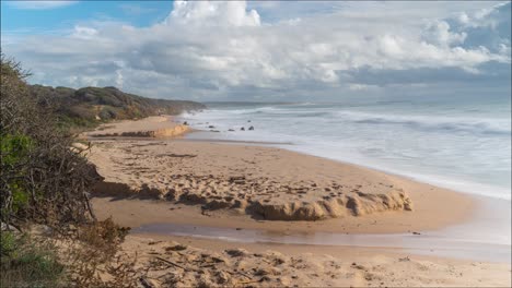 Remote-sandy-beach-with-fluffy-cloudscape-rolling-above,-time-lapse