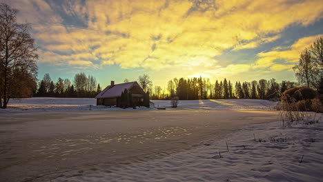 Small-wooden-home-in-winter-landscape-during-bright-vibrant-sunrise,-fusion-time-lapse