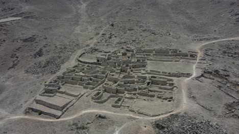 Un-Antiguo-Pueblo-De-Piedra-Abandonado-En-La-Ladera-De-Una-Montaña-Rocosa