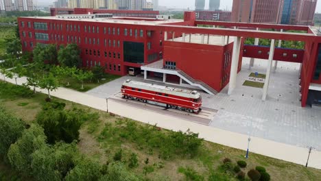 Vista-Aérea-Cinematográfica-Hacia-La-Locomotora-Antigua-En-El-Campus-De-Weihai-De-La-Universidad-De-Jiaotong-De-Beijing,-China