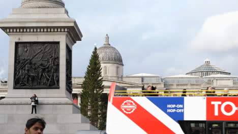 Christmas-Tree-on-Trafalgar-Square,-London-Tour-Bus-Driving-By-SLOMO