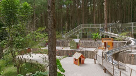 Aerial-flying-in-to-reveal-a-playground-with-children's-curved-slide-and-the-ground-lots-of-white-sand