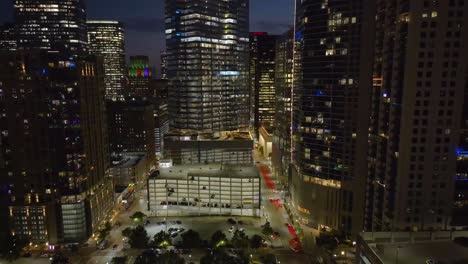 Aerial-view-of-quiet-streets-in-downtown-Houston,-night-in-USA---tracking,-drone-shot
