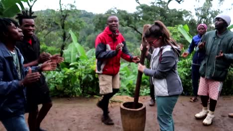 Tribu-Chagga-Africana-Invitando-A-Un-Turista-A-Moler-Granos-De-Café-Arábica-Mientras-Cantan-Y-Bailan