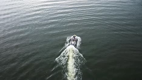 aerial-follow-of-a-watercraft-moving-at-a-high-rate-of-speed-through-an-open-green-lake-in-florida