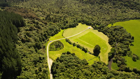 Aerial-view-of-a-green-clearing-in-the-middle-of-a-forest-on-a-sunny-day-in-Dunsdale-Recreational-Reserve