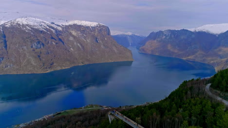 Aerial-view-of-tourist-at-viewpoint-watching-spectacular-fjord-and-mountain-range-view-from-top-in-norway