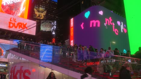 Berühmte-Rote-Treppe-Von-Tkts-Am-Times-Square,-Die-Nachts-In-New-York-City-Mit-Bunten-Digitalen-Werbetafeln-Im-Hintergrund-überfüllt-Sind