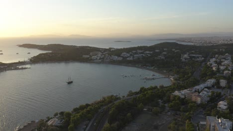 Eine-Luftaufnahme-Eines-Kleinen-Beckens-Mit-Einem-Segelboot-Während-Des-Sonnenuntergangs-Am-Meer-In-Griechenland