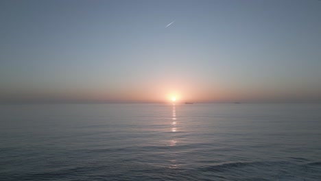 Segelboot-Gleitet-Während-Des-Orangefarbenen-Sonnenuntergangs-über-Das-Wasser